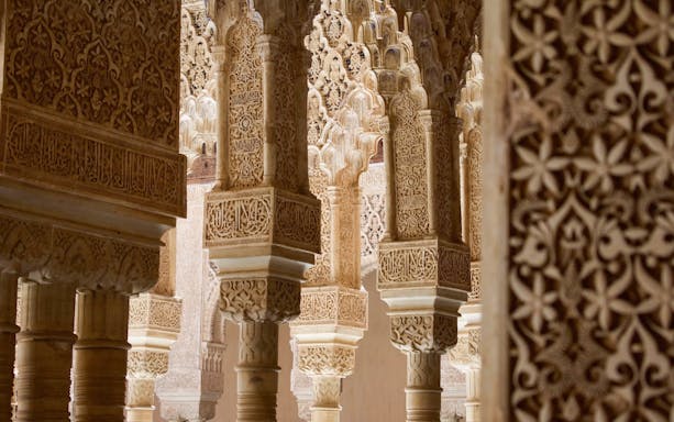 Intricate stucco arches in the Nasrid Palaces, Alhambra, Granada.