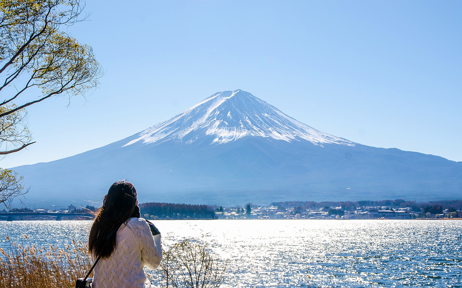 Woman sitting at kawaguchiko lake watching Mount Fuji, Japan