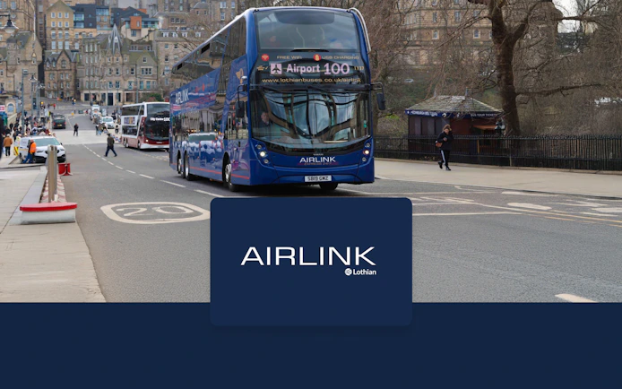 Edinburgh Airlink bus on city street near historic buildings.
