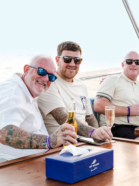 Family enjoying a yacht cruise in Dubai, seated at a table with drinks.