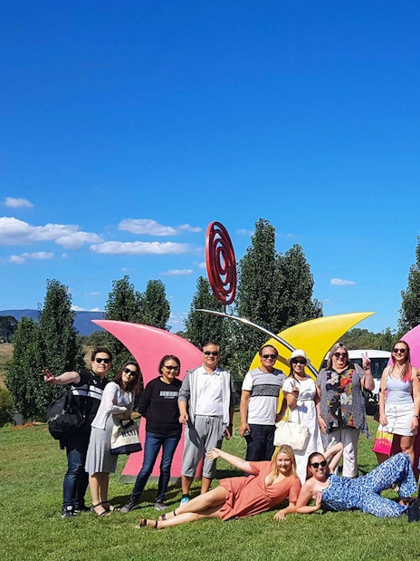 Group enjoying Yarra Valley tour with colorful sculptures and scenic landscape.