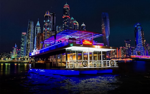 Marina dinner cruise with live music against city skyline at night.