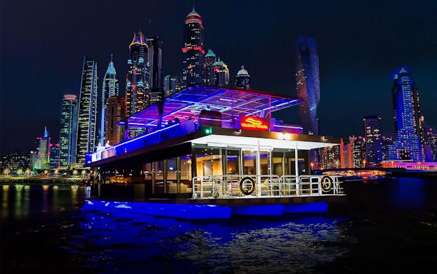 Marina dinner cruise with live music against city skyline at night.