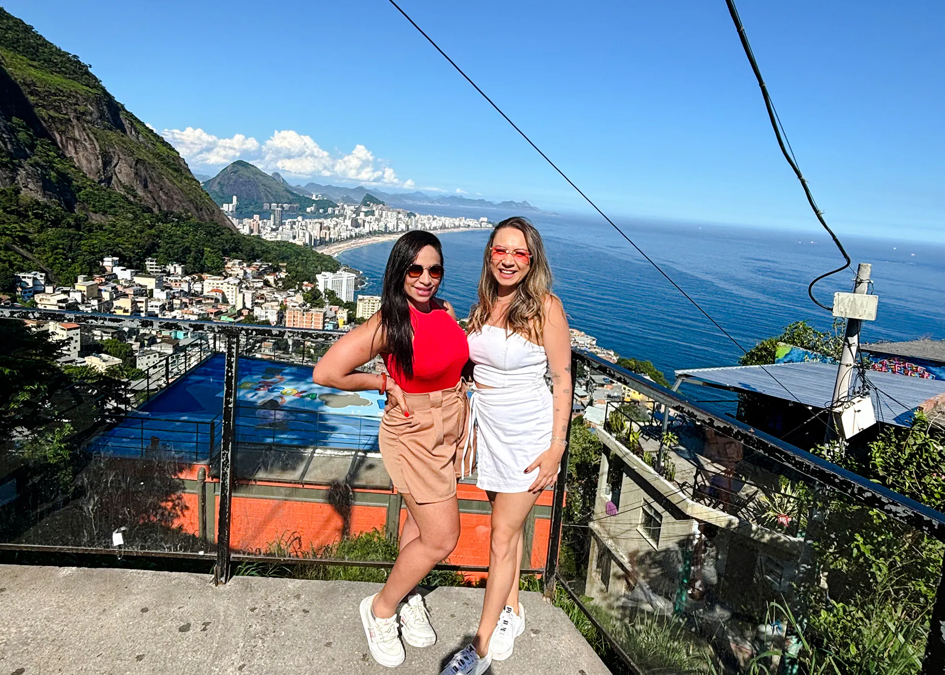 Two people enjoying panoramic views of Rio de Janeiro from Vidigal, with cityscape and ocean in the background.