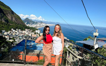 Two people enjoying panoramic views of Rio de Janeiro from Vidigal, with cityscape and ocean in the background.
