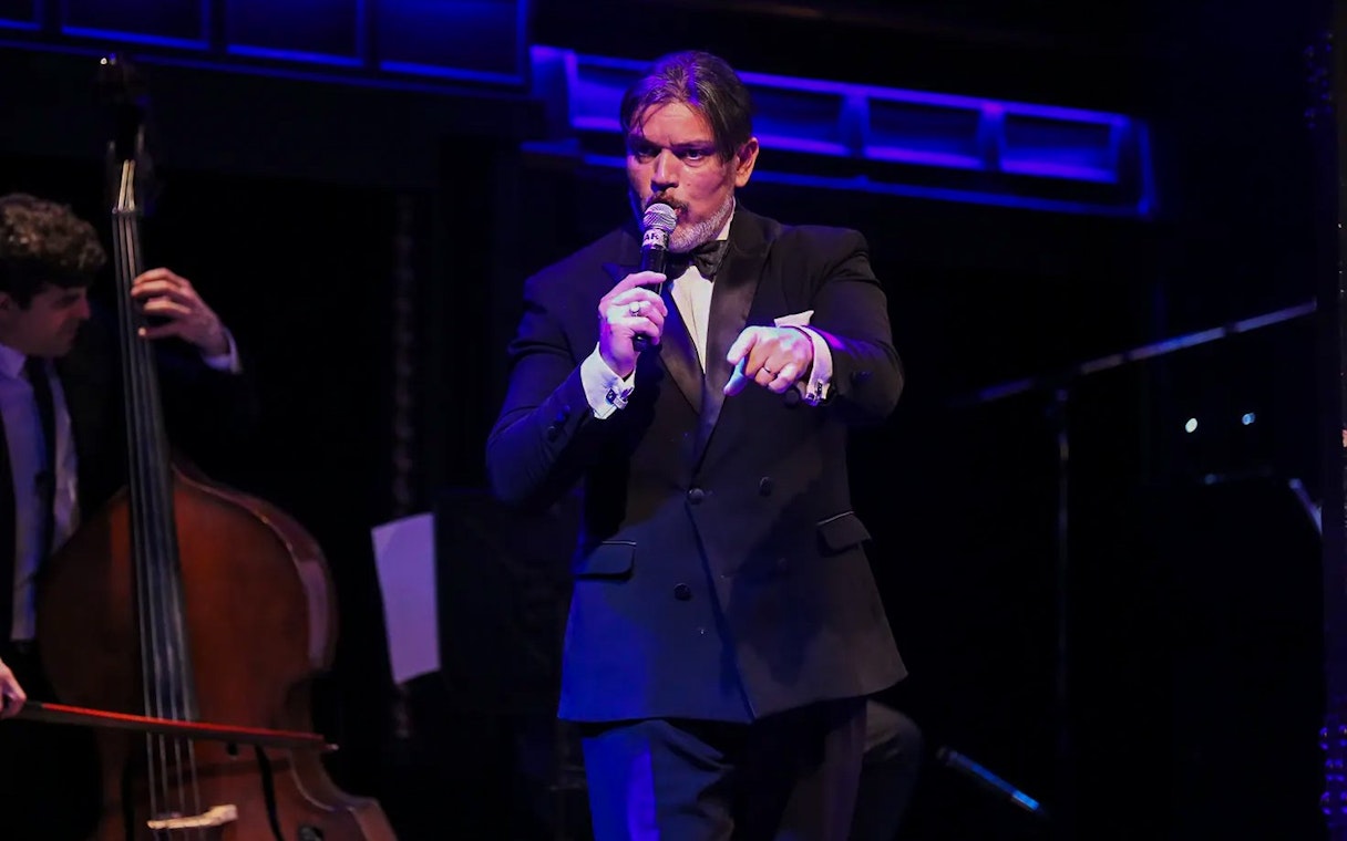 Musician singing at El Querandí Tango Show with double bass player in Buenos Aires.