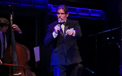 Musician singing at El Querandí Tango Show with double bass player in Buenos Aires.