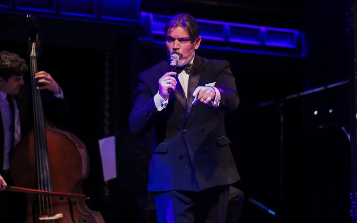 Musician singing at El Querandí Tango Show with double bass player in Buenos Aires.