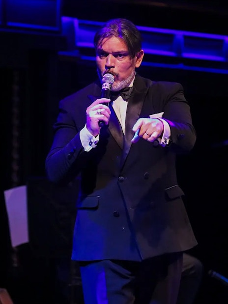 Musician singing at El Querandí Tango Show with double bass player in Buenos Aires.