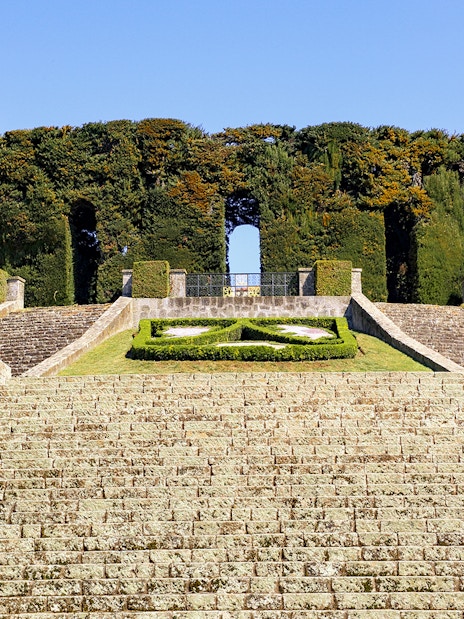 Stone steps leading to Castel Gandolfo's Secret Garden entrance, surrounded by manicured hedges.