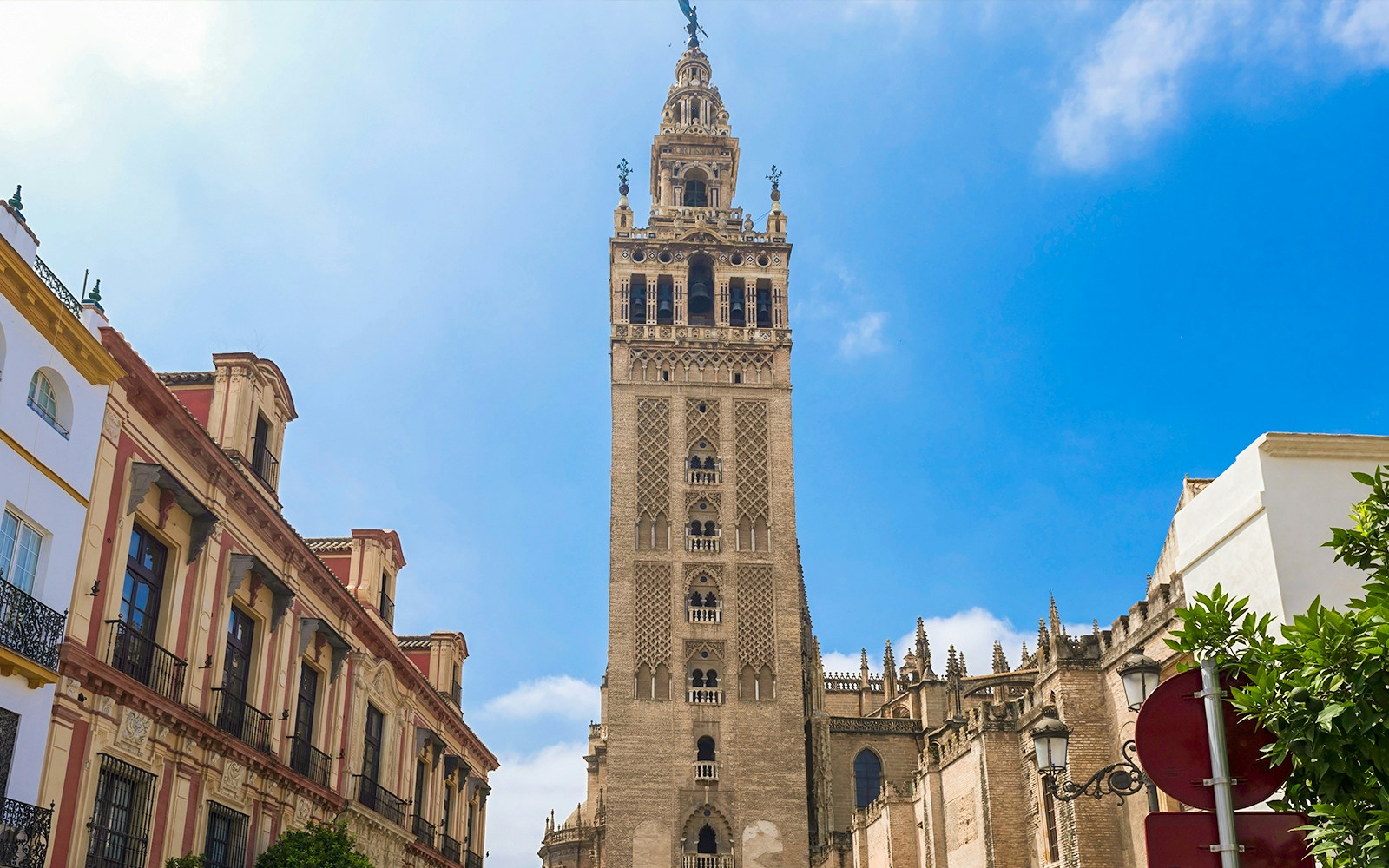 La Giralda tower in Seville with intricate architectural details against a clear sky.