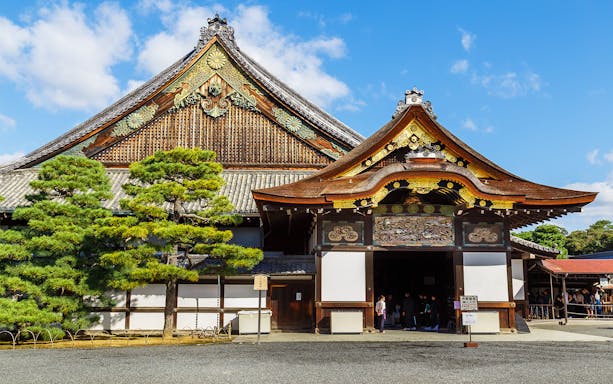 Nijo Castle entrance in Kyoto, Japan, with traditional architecture and visitors.