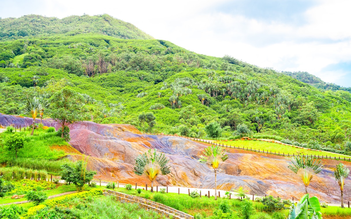 Coloured Earth in Chamarel, Mauritius with vibrant sand dunes and lush green hills.