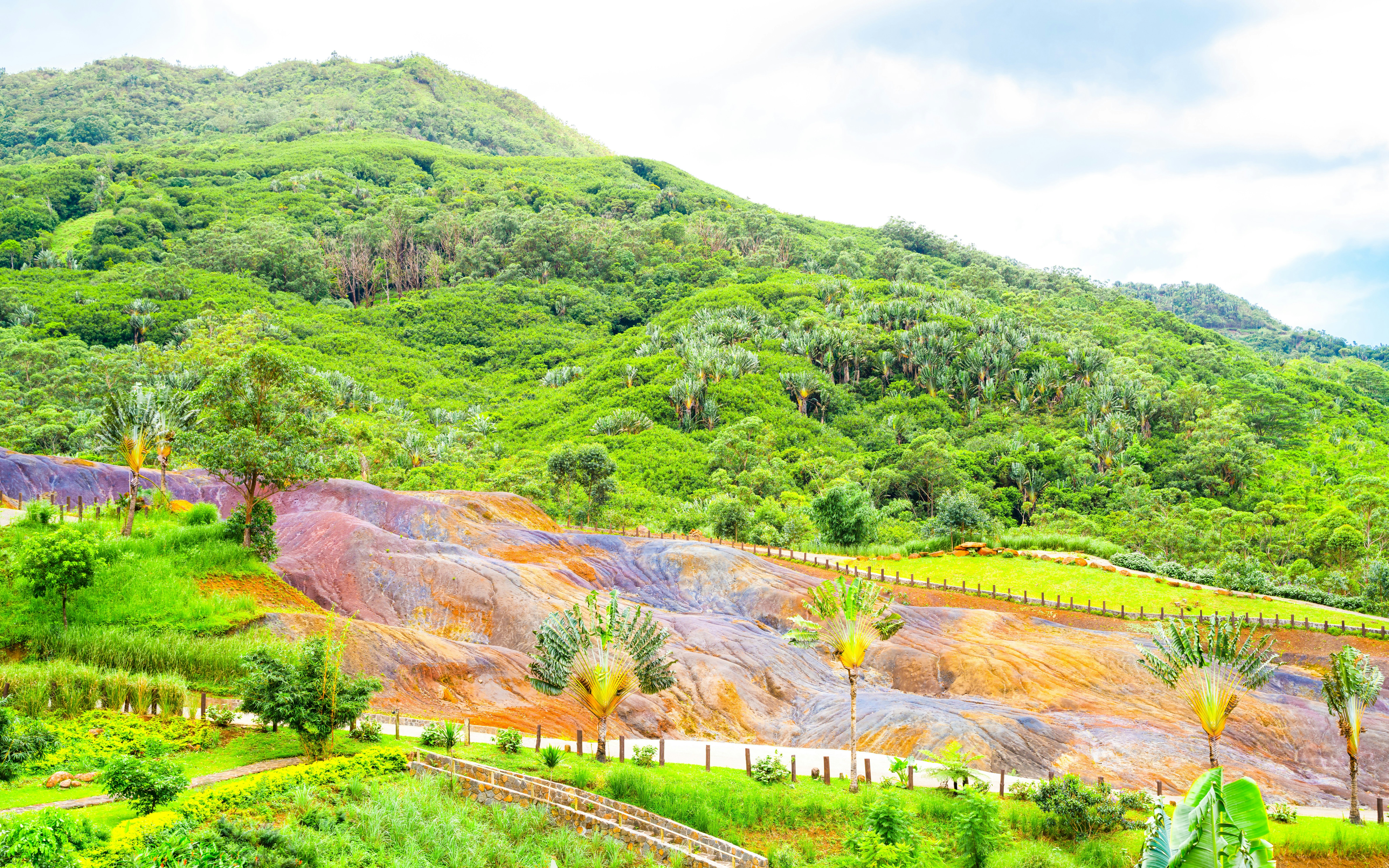 Coloured Earth in Chamarel, Mauritius with vibrant sand dunes and lush green hills.