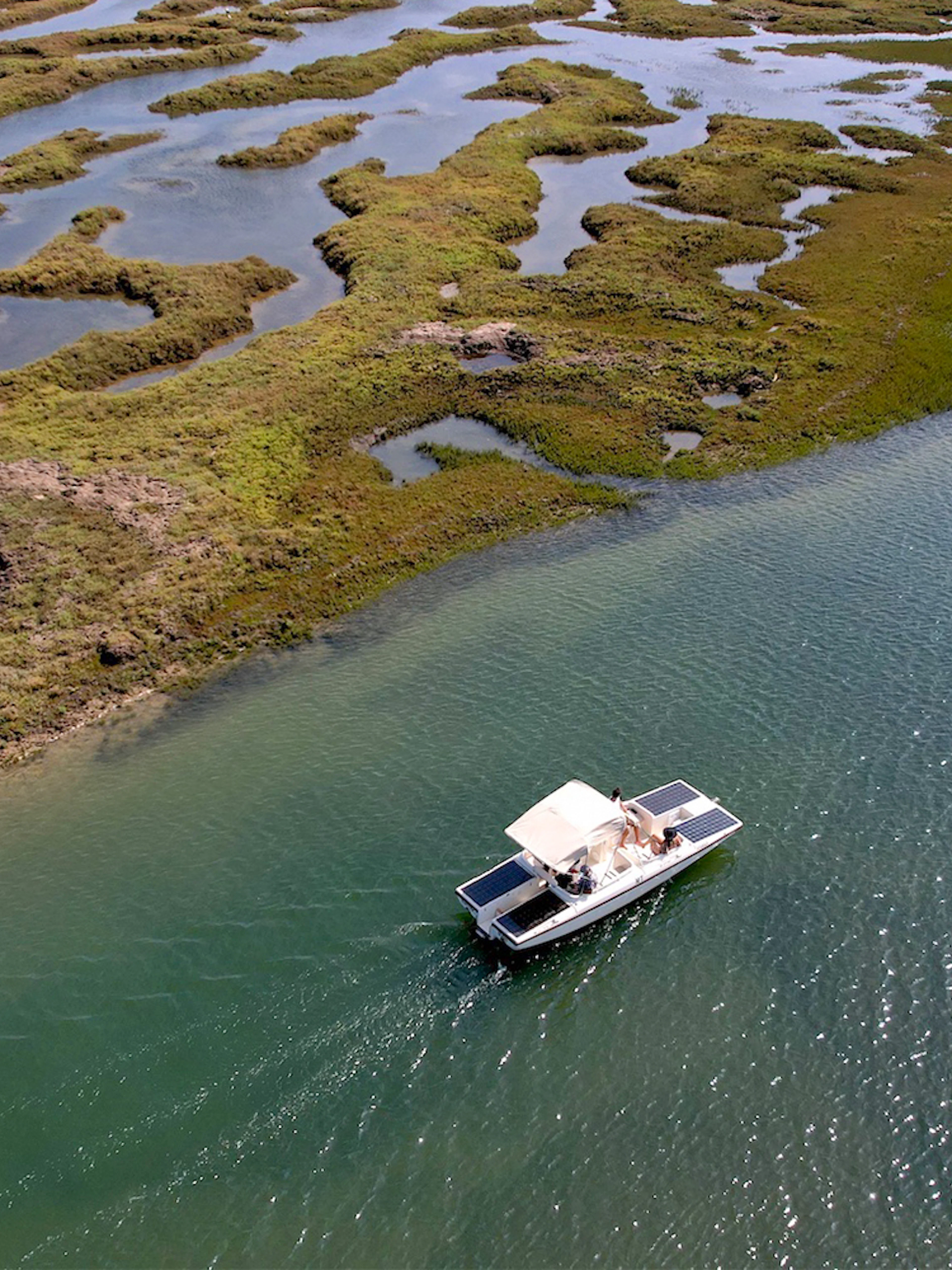 Eco-friendly boat navigating Ria Formosa's winding waterways in Algarve, Portugal.