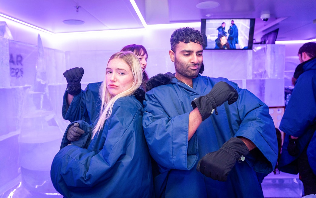 Visitors in blue coats enjoying IceBar Surfers Paradise.