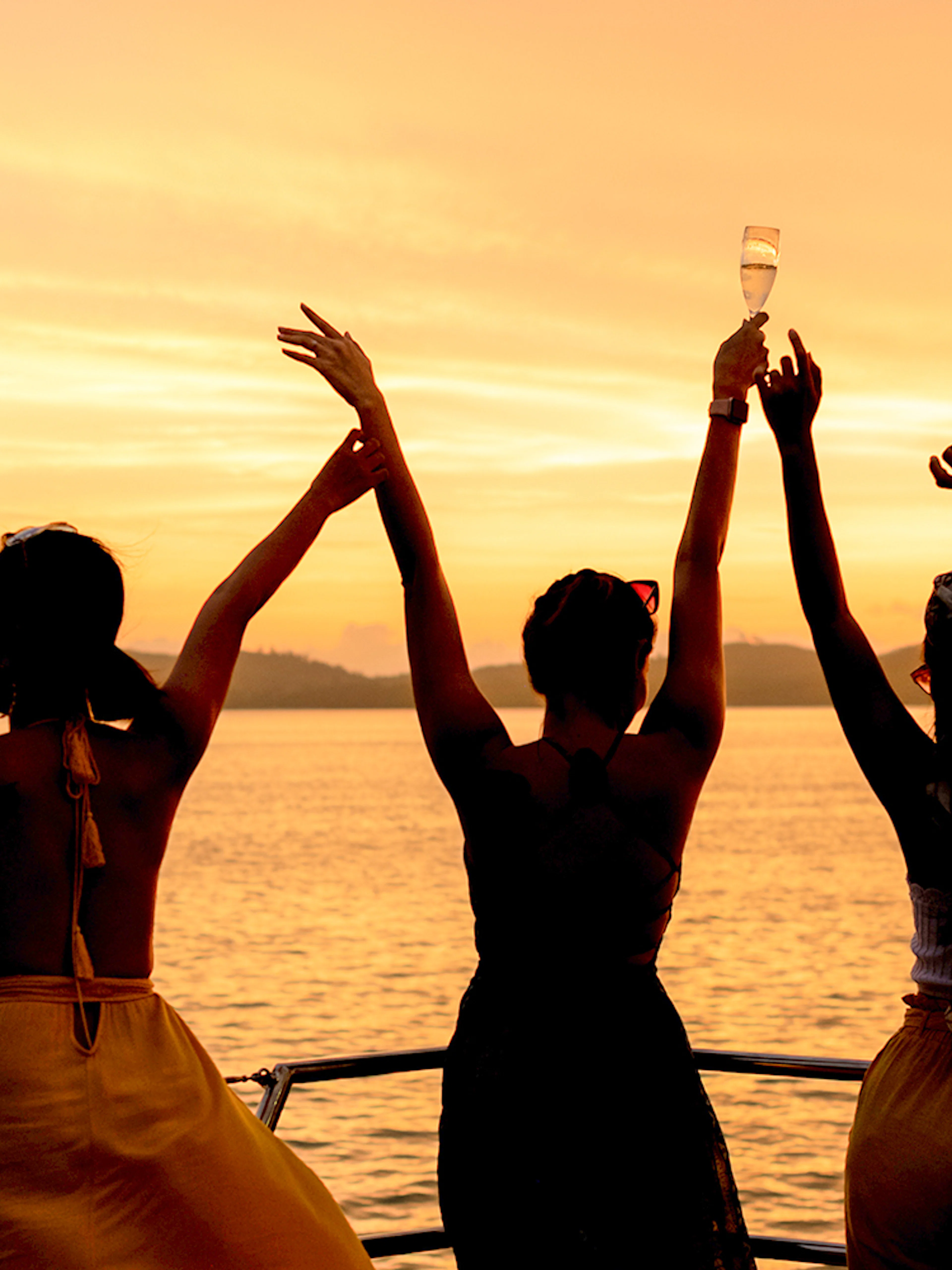 Three people enjoying sunset drinks on a boat in Athens.