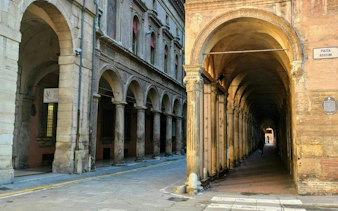 Arched portico in Piazza Rossini, Bologna, part of the self-guided city exploration game.