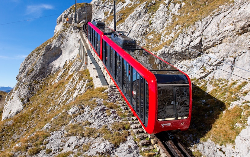 Pilatus Mountain train ascending steep rocky slope in Switzerland.