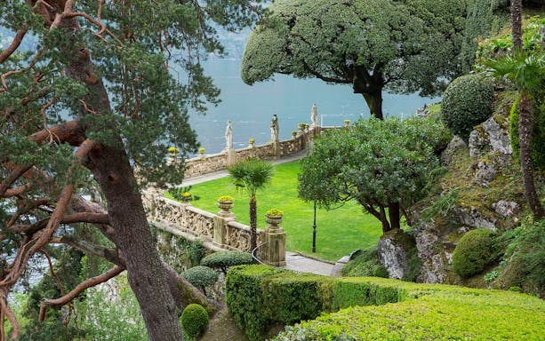 Villa Del Balbianello park with lush greenery and statues overlooking Lake Como.