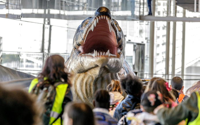 Visitors viewing a large sea monster model at Oceanário de Lisboa's SEA MONSTERS exhibition.