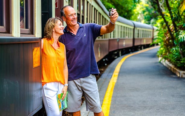 Couple taking a selfie by the Kuranda Scenic Railway train in Cairns.