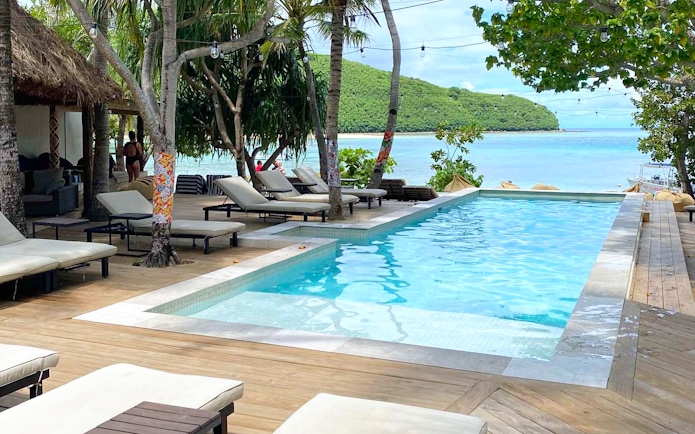 Poolside view at Mantaray Island Resort, Fiji with loungers and ocean backdrop.
