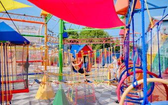 Children playing on colorful playground equipment during a birthday party in Phuket.