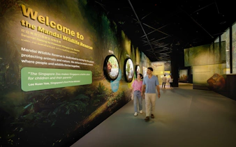 Tourists walking through Mandai Wildlife Reserve entrance exhibit in Singapore.