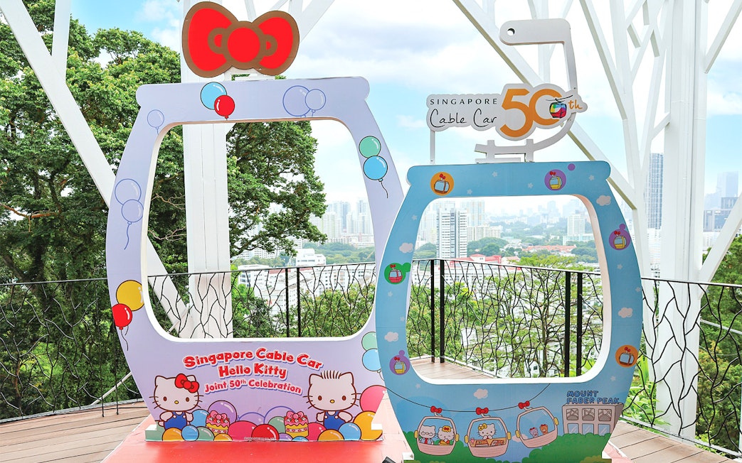 Singapore Cable Car Hello Kitty 50th celebration frame with city skyline in background.