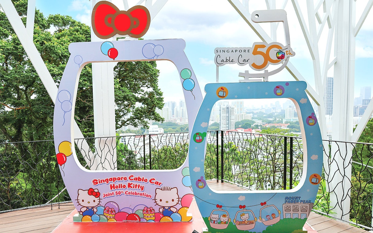 Singapore Cable Car Hello Kitty 50th celebration frame with city skyline in background.