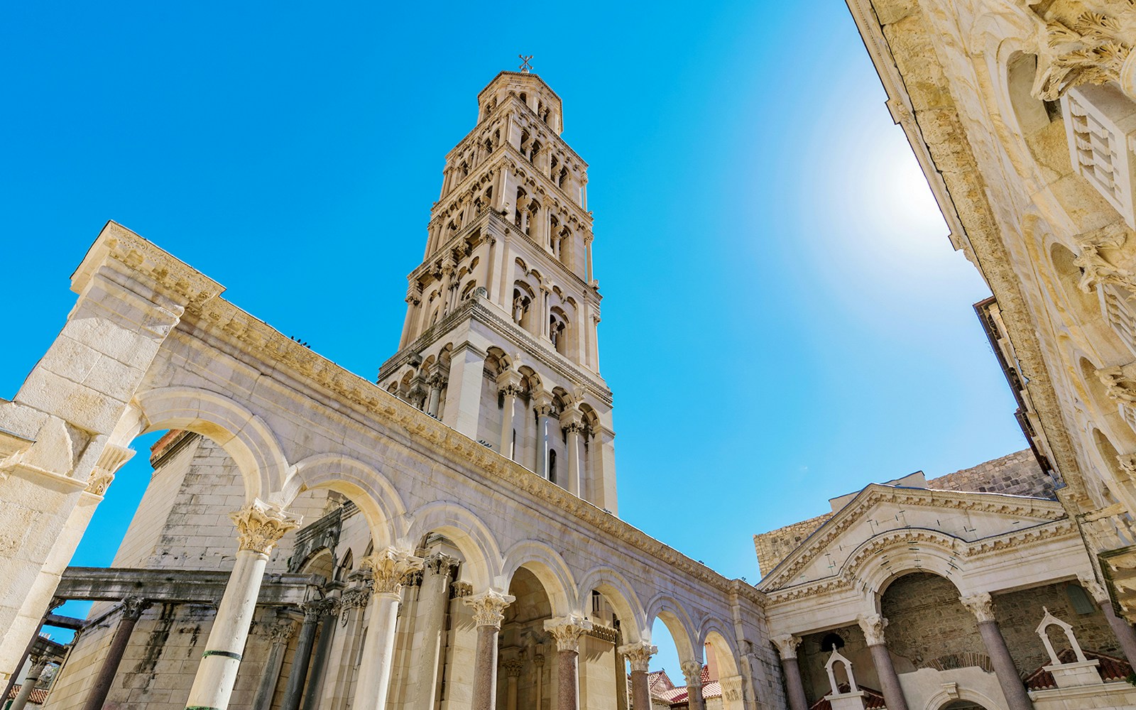 Diocletian's Palace bell tower and arches in Split, Croatia, under a clear blue sky.