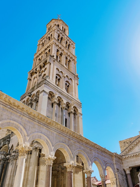 Diocletian's Palace bell tower and arches in Split, Croatia, under a clear blue sky.