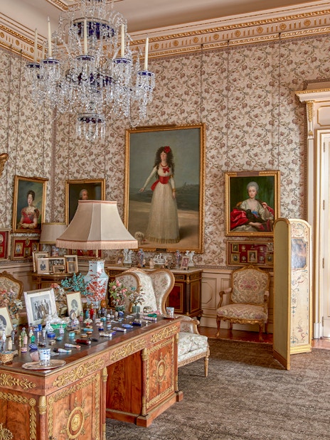 Photos and paintings in an ornate room at Liria Palace, featuring classic furniture and decor.