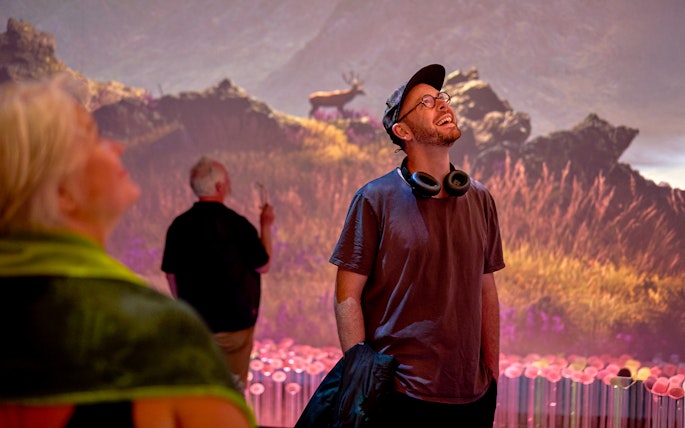 Visitors enjoying a sensory video journey through Scotland with scenic landscapes.