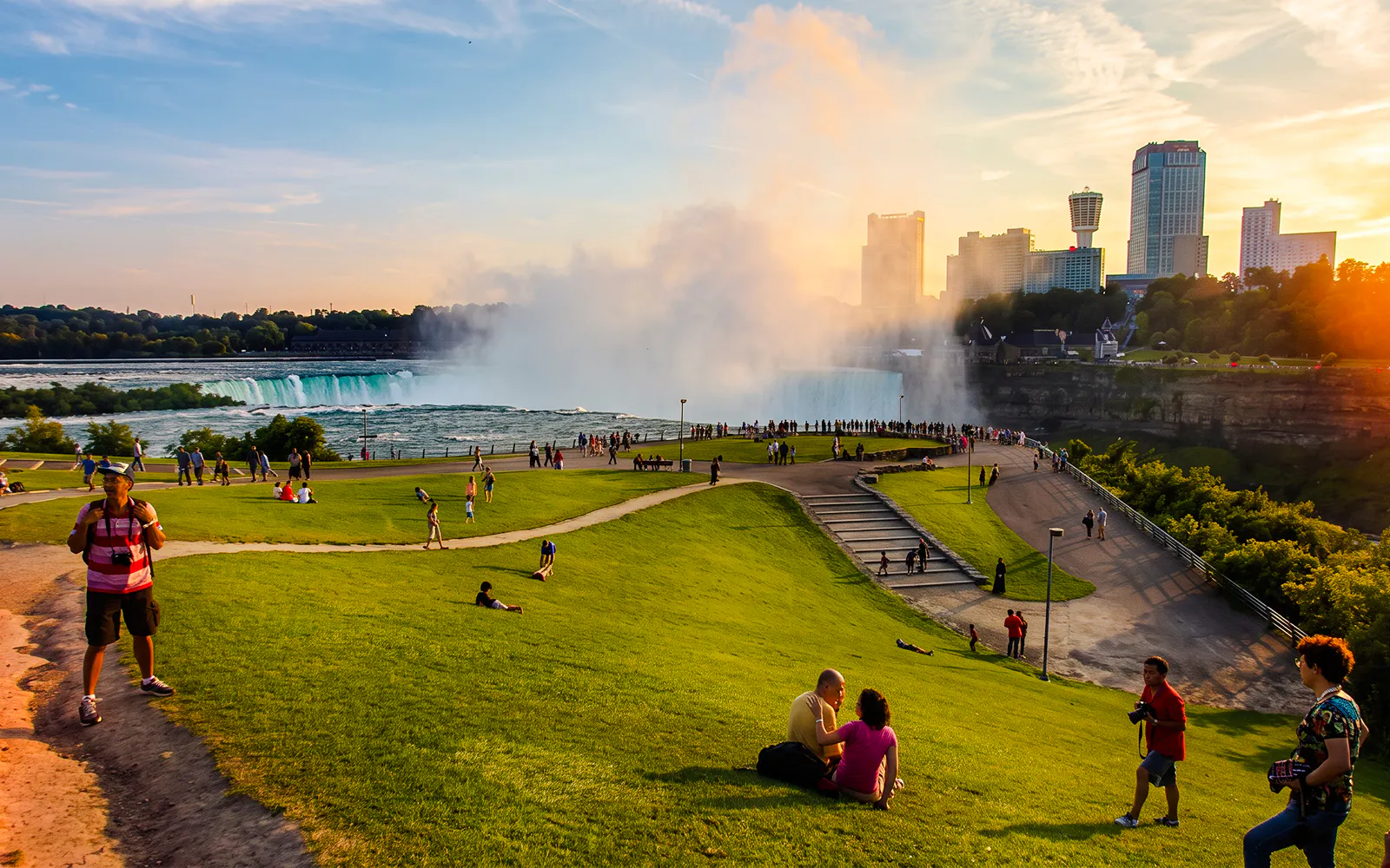 Walking tour near Niagara Falls with view of mist and city skyline.