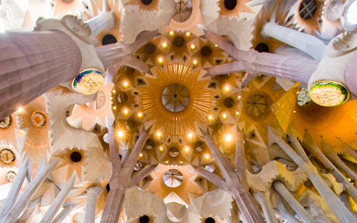 Ceiling of Sagrada Familia with intricate geometric patterns and columns, Barcelona.