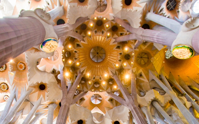 Ceiling of Sagrada Familia with intricate geometric patterns and columns, Barcelona.