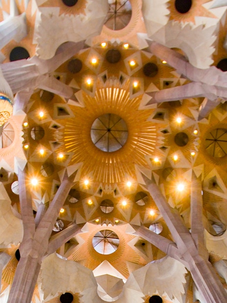 Ceiling of Sagrada Familia with intricate geometric patterns and columns, Barcelona.