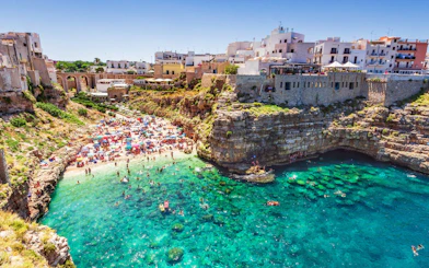 Polignano a Mare beach with cliffs and turquoise water, Valle d'Itria tour.