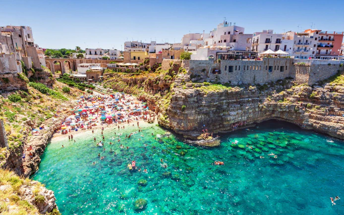 Polignano a Mare beach with cliffs and turquoise water, Valle d'Itria tour.