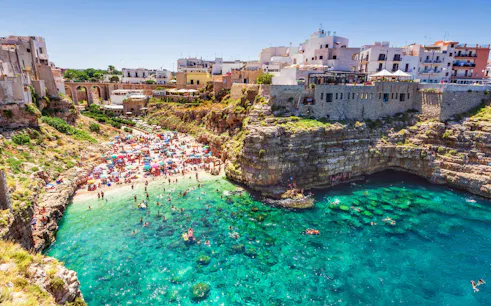 Polignano a Mare beach with cliffs and turquoise water, Valle d'Itria tour.
