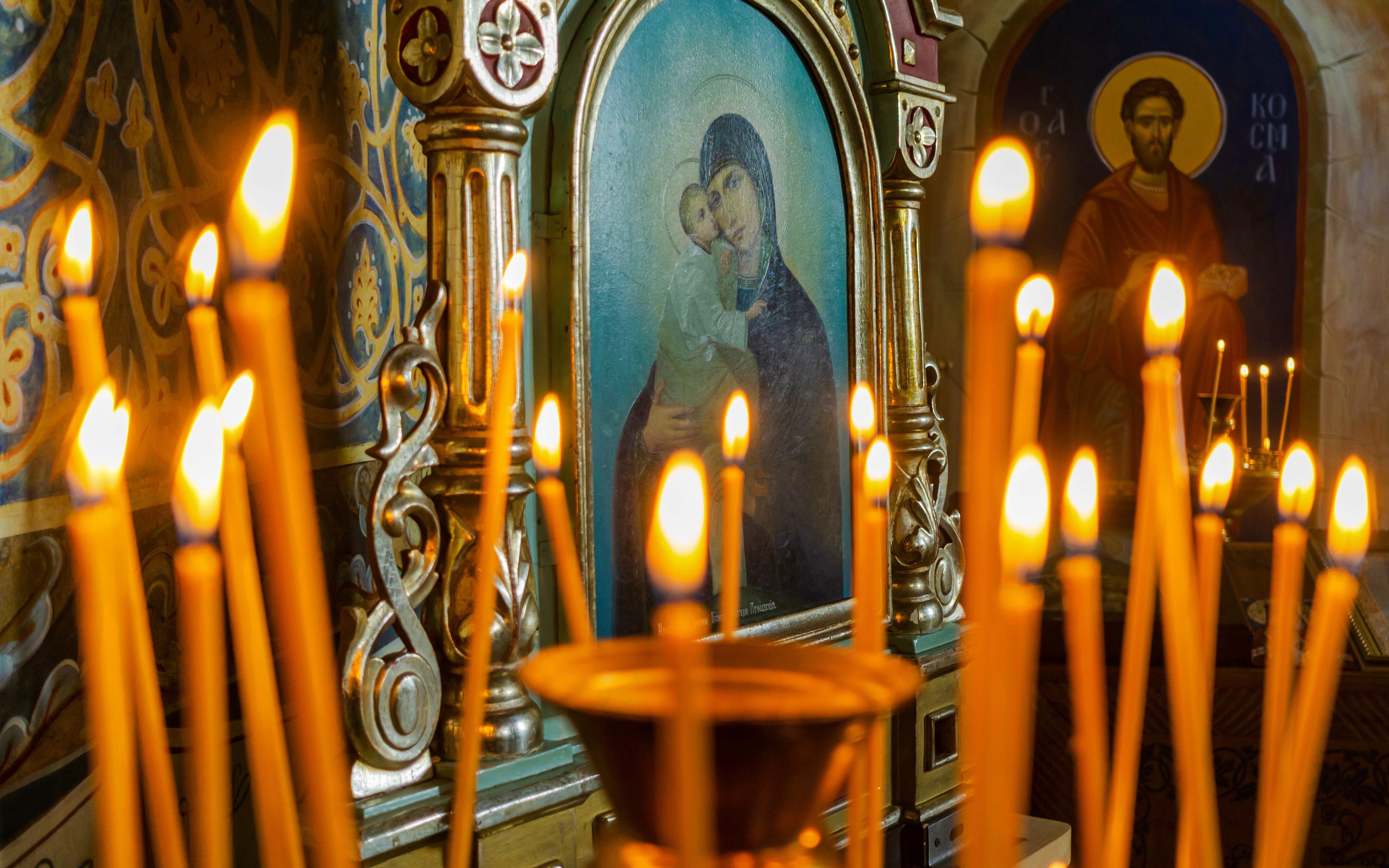 Candles lit in front of religious icons during Christmas service at Canterbury Cathedral.