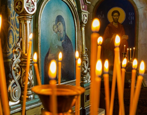 Candles lit in front of religious icons during Christmas service at Canterbury Cathedral.