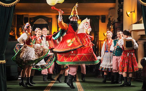 Performers in traditional Polish costumes dancing at Jama Michalika Cafe folk show.