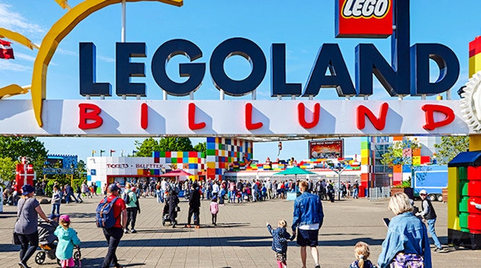 Entrance to LEGOLAND Billund with families walking towards the colorful park entrance.