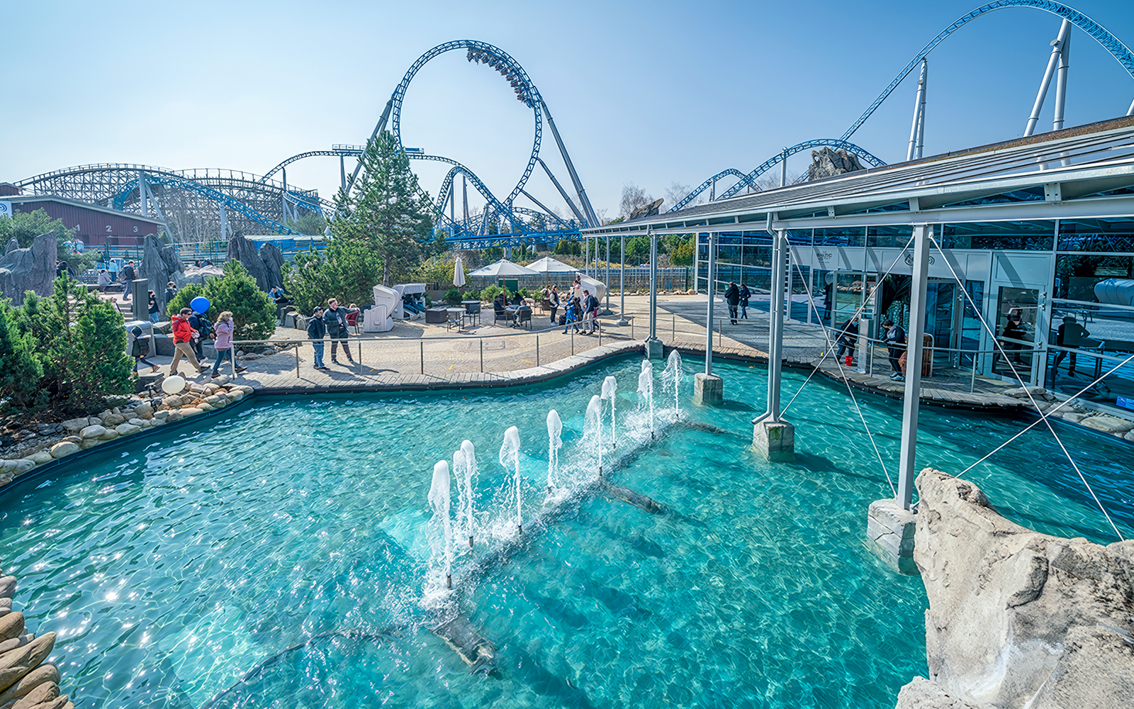 Atlantica SuperSplash ride with fountains and roller coaster in the background.