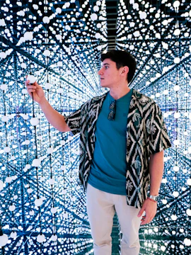 Person exploring Bubble Planet light installation.