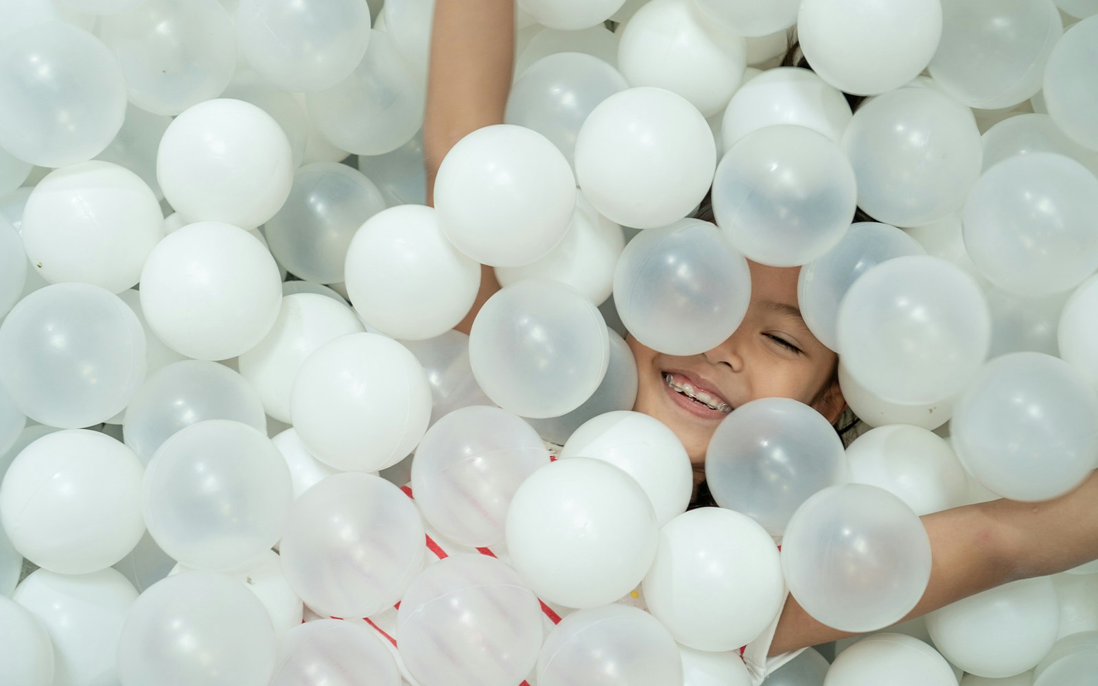 Child playing in a ball pit at Upside Down Museum in Amsterdam.
