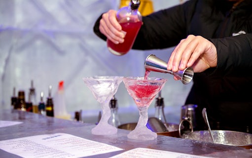 Bartender pouring red cocktail into ice glasses at IceBar Melbourne.